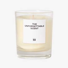 Load image into Gallery viewer, Candle in a glass jar with a white label reading 'The Unforgettable Scent' on a white background